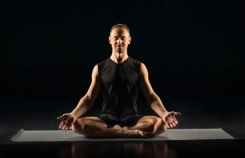 Man seated in Lotus Pose, representing how yoga develops mental focus, stress control, and composure under fatigue through breath and mindful awareness.