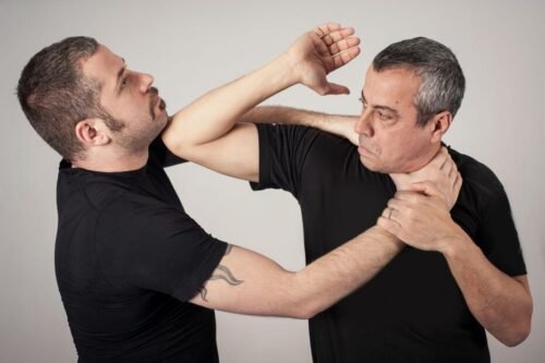 Krav Maga practitioner delivering a close-range elbow strike during a self-defence training scenario.