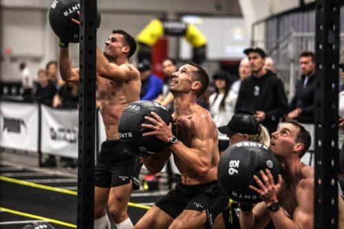 Athletes performing wall balls during a Hyrox event, highlighting strategy and precision for success.