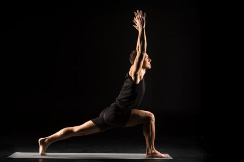 Man in Crescent Lunge pose demonstrating how yoga develops isometric strength, joint stability, and balance under controlled tension.