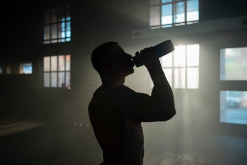 Man drinking water to support hydration, digestion, and overall physical performance.