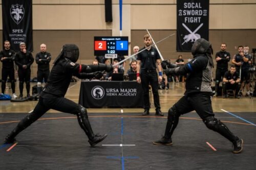 Two HEMA practitioners engage in a competitive longsword bout during a modern tournament, applying reconstructed historical techniques in a live environment.