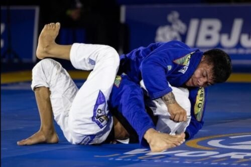 Two Brazilian Jiu-Jitsu competitors grappling during a tournament match.